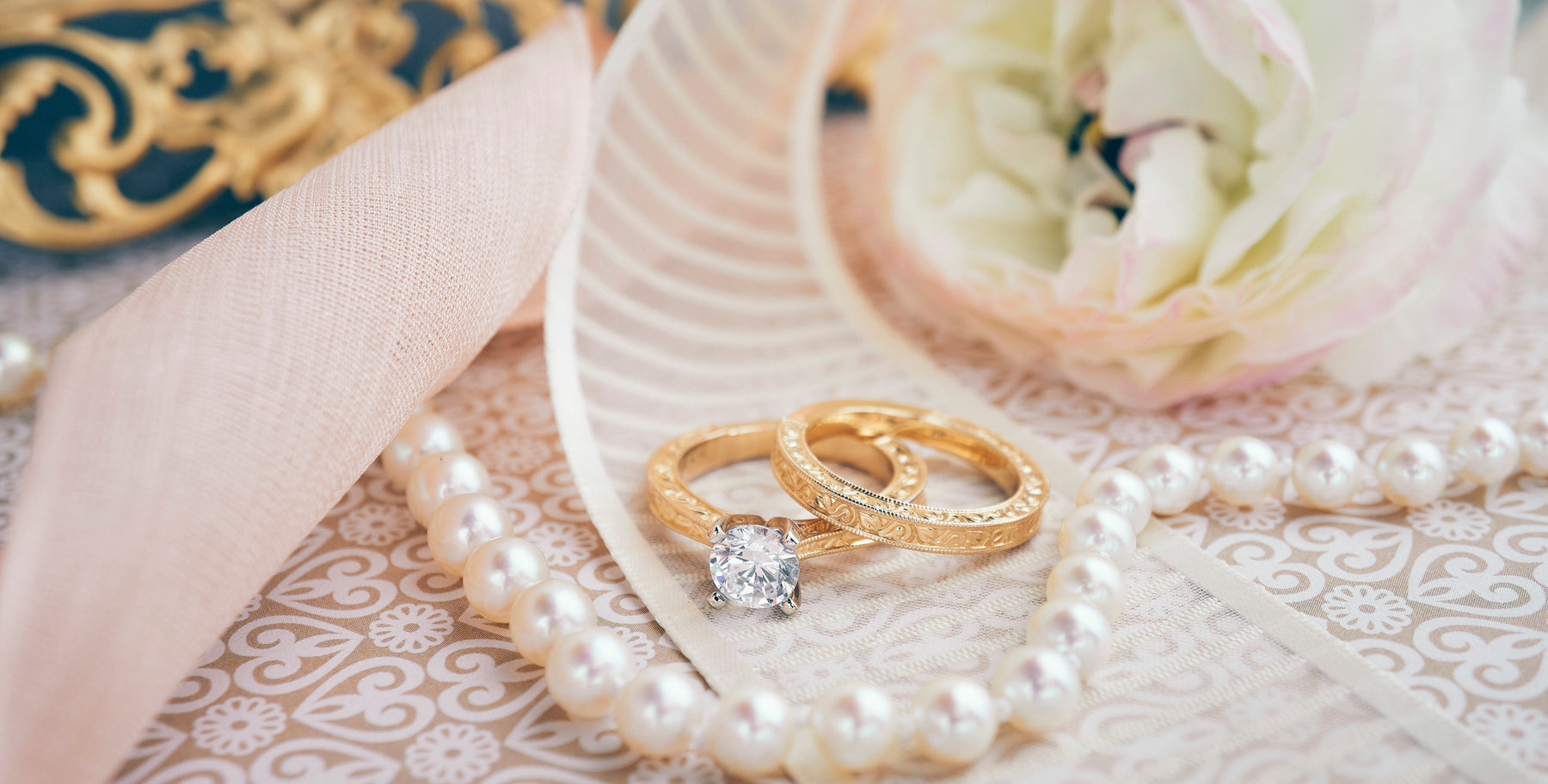 Diamond engagement ring, wedding band, and pearl necklace