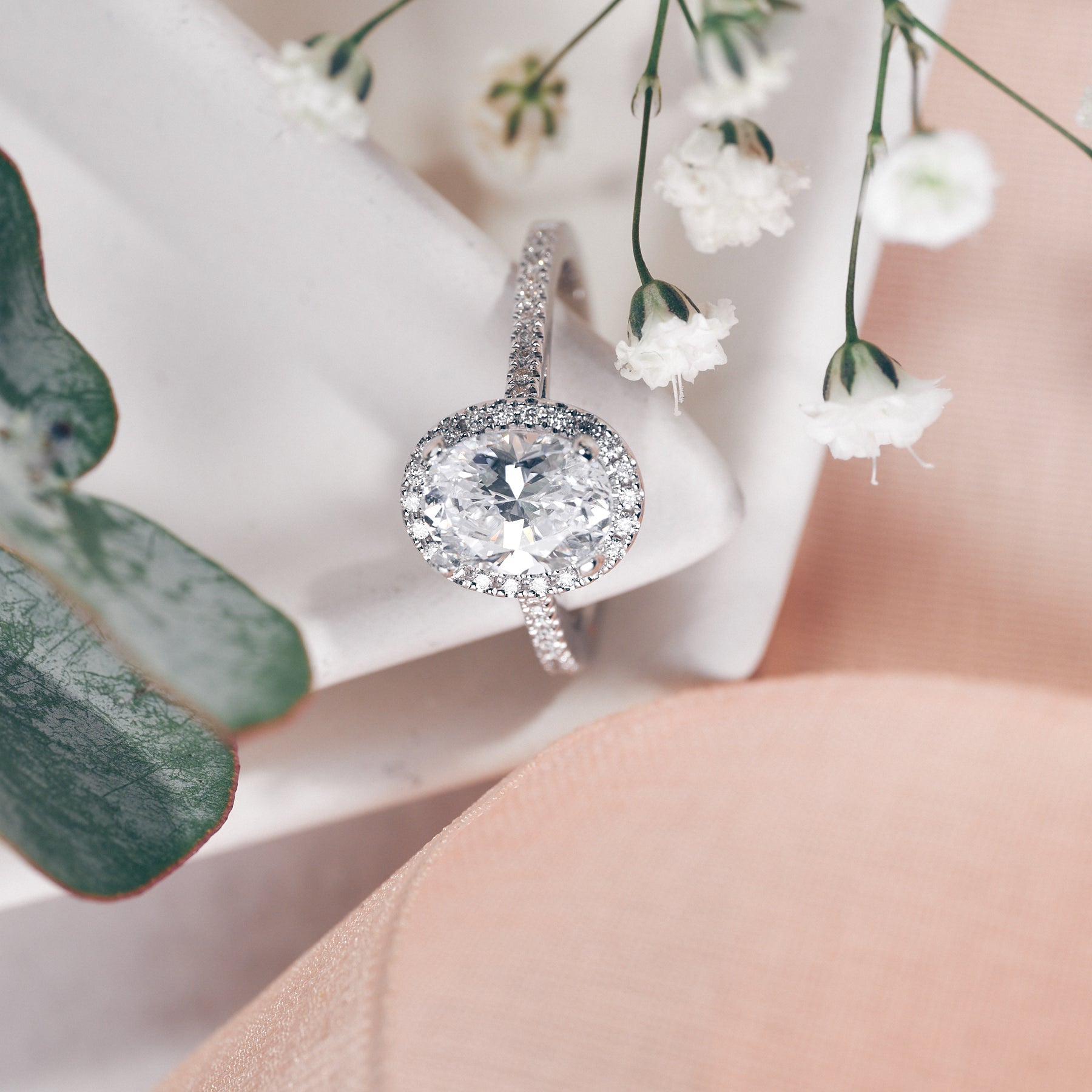 Diamond ring on display with delicate flowers